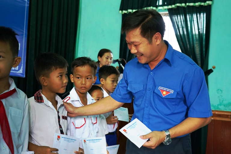 Đồng chí Nguyễn Khánh Vũ - UV BCH Trung ương Đoàn, Bí thư Tỉnh Đoàn trao quà cho các em học sinh
